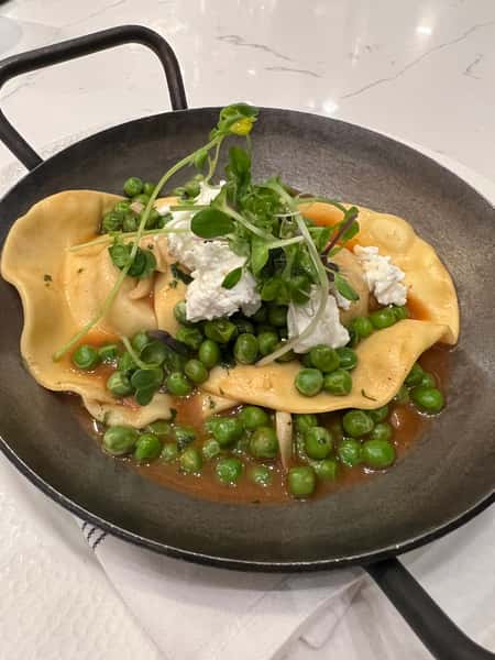 House-made ravioli with peas, mushrooms, fresh herbs, and grated Parmesan at Dulivia Ristorante Italiano in Springdale, Utah.