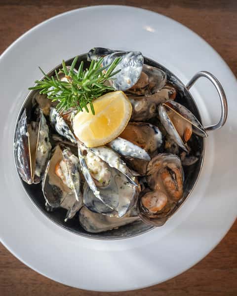 There’s something irresistible about a bowl of mussels arriving at the table still steaming, each shell opening into tender, briny perfection, bathed in a silky white wine cream sauce.

Garlic, butter, herbs, and the taste of the sea come together in every bite. Then come the pommes frites, ready to catch the sauce. The bread follows, because leaving even a spoonful behind would be unthinkable.

Rich, seductive, and meant to be savored slowly.

Moules Rabelais- a dish you think about long after the bowl is empty.

#frenchrestaurant  #houstontexas #ricevillage  #riceuniversity #winebar