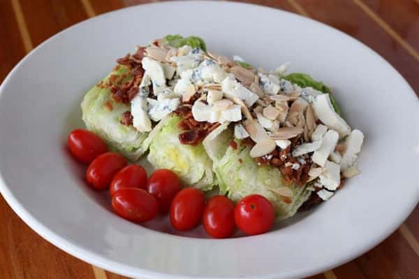 Wedge salad - Crispy roma lettuce with gorganzola crumbles, cherry tomatoes, bacon & toasted almonds