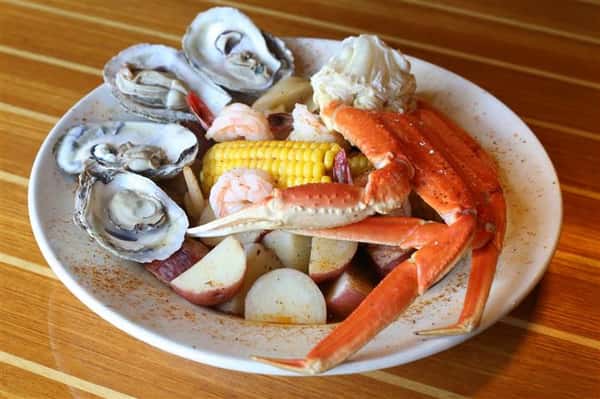 Low Country Boil - Shrimp, crab legs & oysters steamed fresh served in a spicy broth with onions, corn, potatoes & smoked sausage
