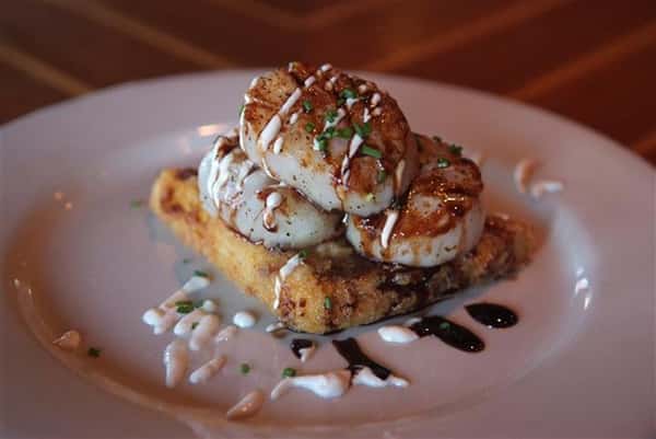 Scallops - Caramelized & served on a fried grit cake with a smoked chili cream & balsamic glaze