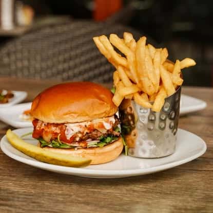Burger served with fries in a metal cup