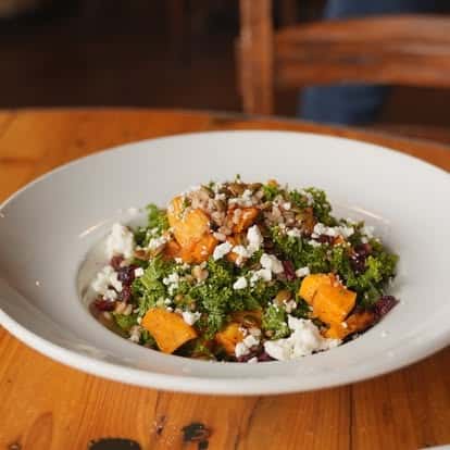 Grain bowl salad with roasted squash, greens, and nuts