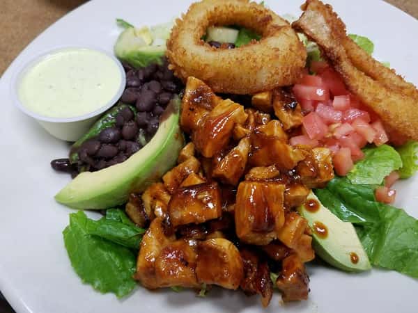 Marinated sliced meat mixed with avocado, lettuce, and onion rings