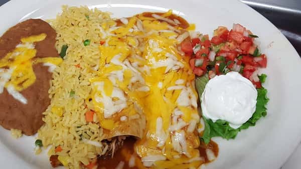 Enchilada covered with cheese next to rice, pico de gallo, and beans