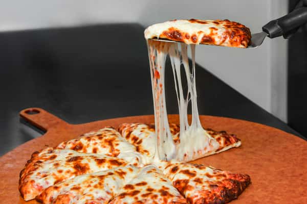 A slice of pizza with cheese stretching as it is pulled up