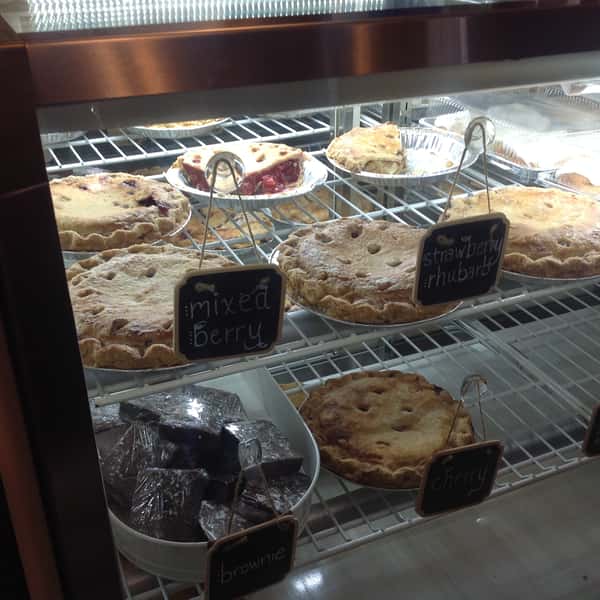 Assortment of golden brown pies and dark brownies in a display case at The Sunflower Bakery Café.