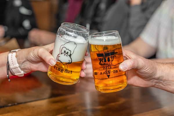 Friends toasting with beer at The Wing Hut