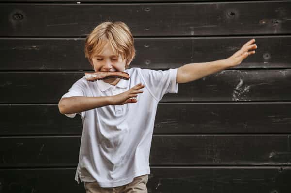 boy dabbing holding bbq rib in his mouth
