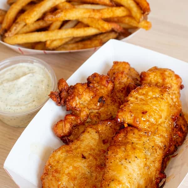 Crispy chicken tenders tossed in sweet and spicy glaze, served with seasoned fries and creamy dipping sauce at Social Burger.