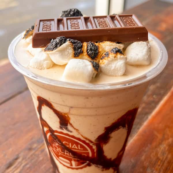 Chocolate milkshake topped with toasted marshmallows, chocolate cookie crumbles, and a Hershey's milk chocolate bar at Social Burger.