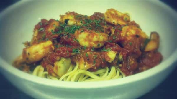 Spaghetti with a think red sauce and shrimp.
