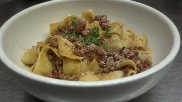 Pasta with meat sauce and topped with parmesan cheese.