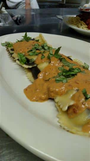 Raviolis topped with a light sauce.