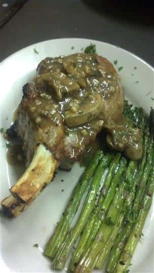 Meat topped with marsala and a side of asparagus.