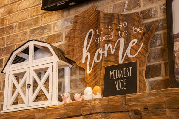 Warm café interior with rustic wood décor, cozy lighting, and decorative signage, creating a welcoming coffee shop atmosphere with a homey, inviting vibe.