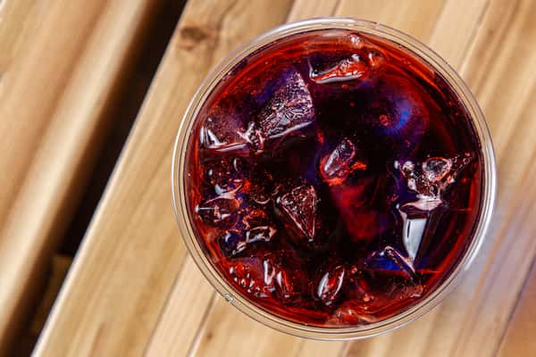 Top view of vibrant red iced drink with ice cubes at Wisco Coffee Company