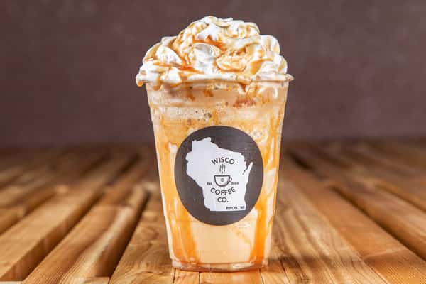 Caramel latte topped with whipped cream and caramel drizzle at Wisco Coffee Company
