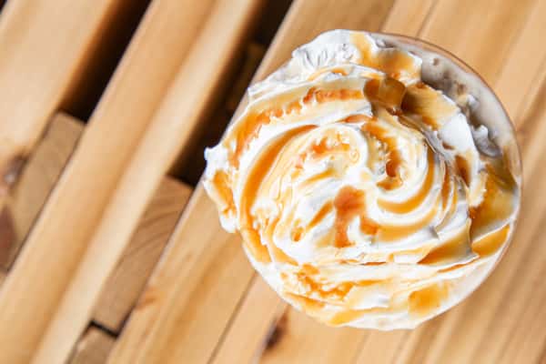 Caramel latte topped with whipped cream and caramel drizzle at Wisco Coffee Company