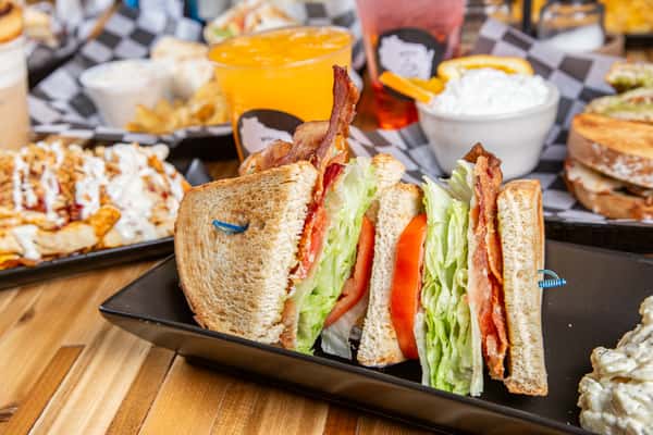 Club sandwich with bacon, lettuce, and tomato served with chips at Wisco Coffee Company
