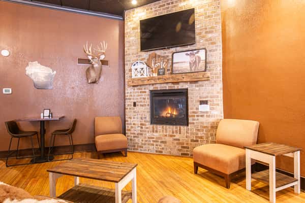 Warm café interior with rustic wood décor, cozy lighting, and decorative signage, creating a welcoming coffee shop atmosphere with a homey, inviting vibe.