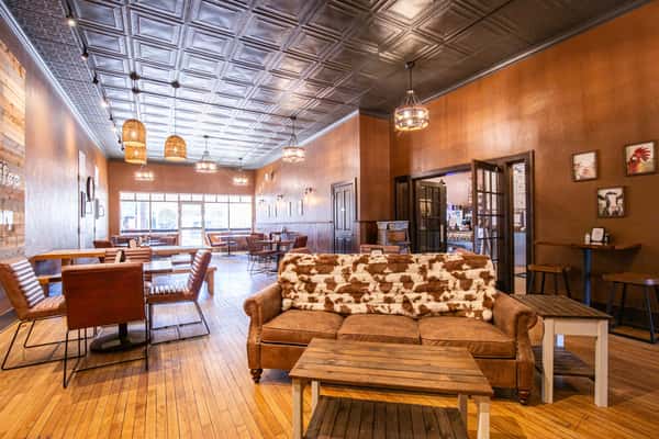 Warm café interior with rustic wood décor, cozy lighting, and decorative signage, creating a welcoming coffee shop atmosphere with a homey, inviting vibe.