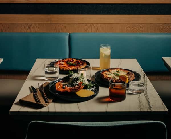Table with plates of food and cocktails
