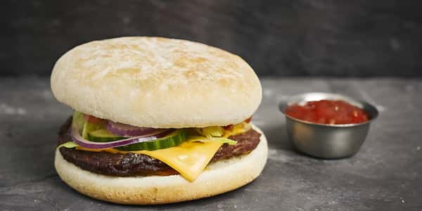 Cheeseburger with lettuce, tomato, onion, and melted cheese on a soft bun.
