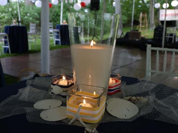 several candles on a table with seashells