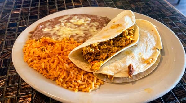 Seasoned beef burrito served with Mexican rice and refried beans at Maya Mexican Restaurant, featuring classic Tex-Mex flavors.