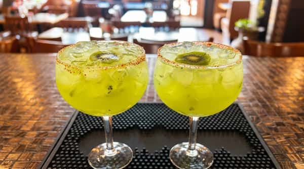 Two handcrafted kiwi margaritas served at the bar at Maya Mexican Restaurant, a vibrant Tex-Mex restaurant in Homewood and Alabaster, Alabama.