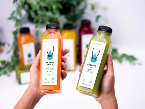 Hands holding two bottles of juices