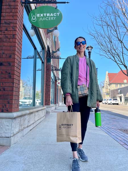 Customer with a takeout bag from Extract Juicery