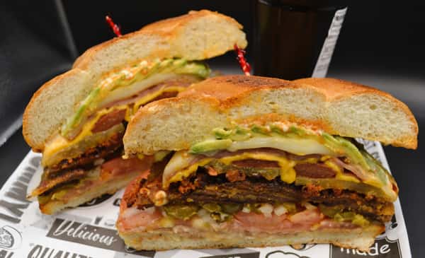 The Cuban torta comes with all three meats Milanesa beef, chorizo, and salchicha plus ham, pineapple, American cheese, refried beans, mozzarella cheese, tomatoes, onions, jalapenos, chipotle sauce, avocado, and mayonnaise on a traditional Mexican bread. (Fridays and Saturdays only)