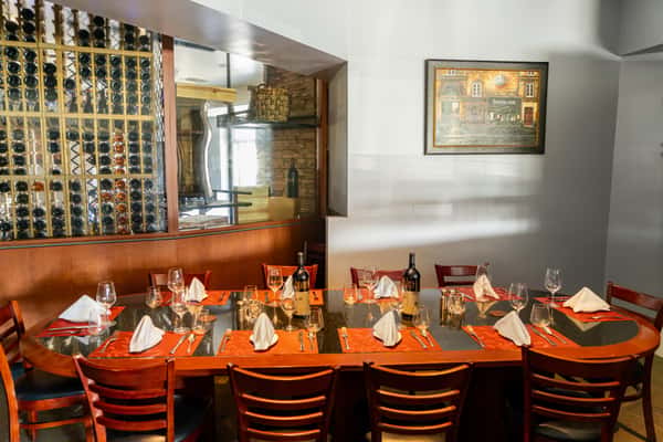 Elegant dining setup at 17th Street Grill, Tustin, CA, showcasing menus on the table with a sophisticated backdrop of wine bottles, suitable for private functions.