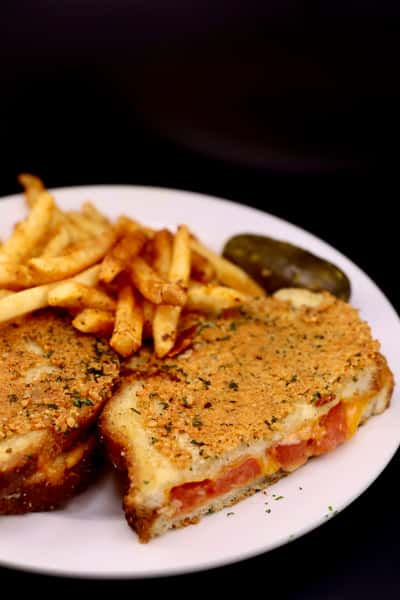 breaded schnitzel with golden fries and pickle on a plate