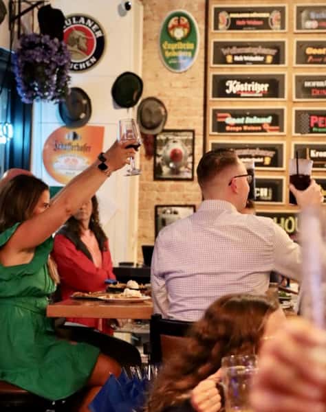 group of friends raising beer steins in a lively Bavarian restaurant setting