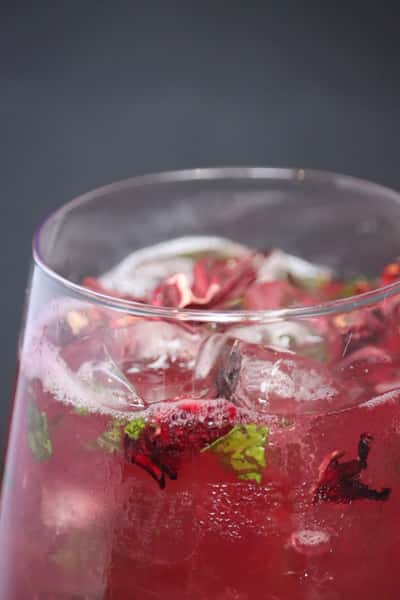 refreshing pink cocktail with ice and fruit garnish in glass