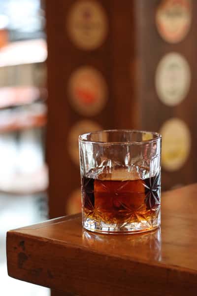old fashioned cocktail in rocks glass on bar counter