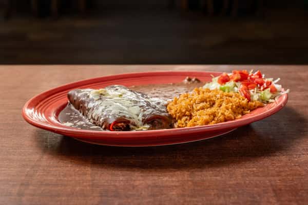 Cheesy beef enchiladas smothered in rich mole sauce, paired with refried beans, Mexican rice, and a fresh salad on a classic Tex-Mex plate.