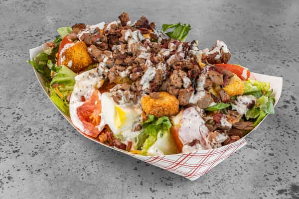 Chopped BBQ meat salad with fresh romaine lettuce, tomatoes, shredded cheese, crispy croutons, and ranch dressing — a hearty, protein-packed salad option.