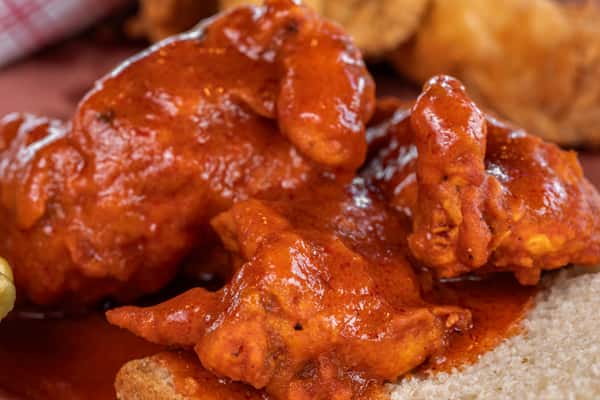Juicy buffalo chicken wings coated in tangy hot sauce, served on white bread — a classic appetizer or game-day essential with bold flavor.