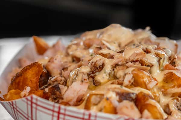 Crispy potato wedges loaded with chopped smoked meat and drizzled with creamy house sauce — a hearty and savory side or entree option for BBQ lovers.