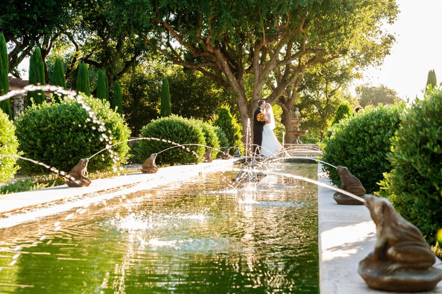 Bride and groom beside the courtyard fountain at The River Mill