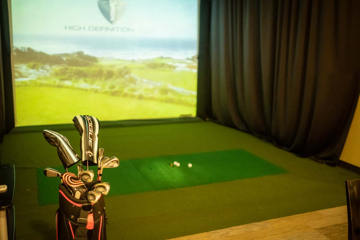 Golf clubs sitting with the golf simulator