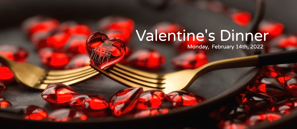 Valentine's Dinner dateline 2 gold forks mentwined holding single red glass heart on black plate with red glass hearts background
