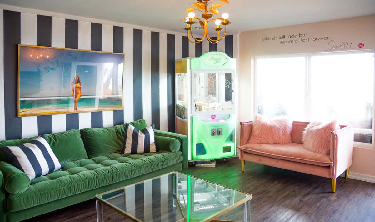 photo of green and pink couches and black and white striped wallpaper