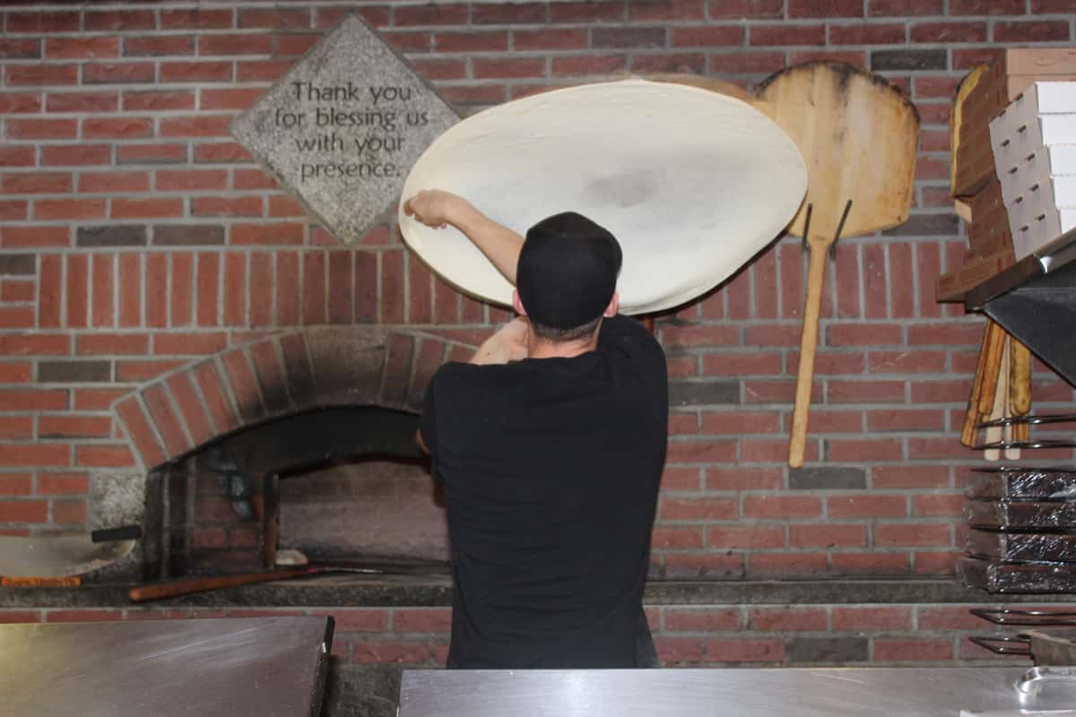 guy tossing pizza dough