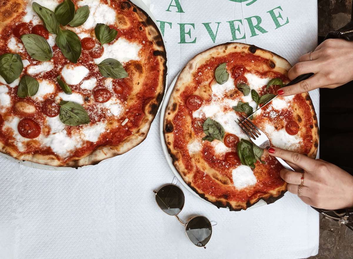 person cutting pizza