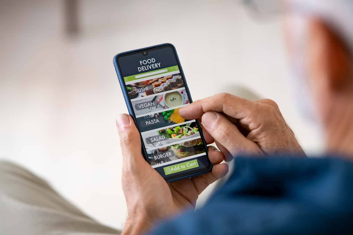 Guest using a food delivery app on their mobile phone